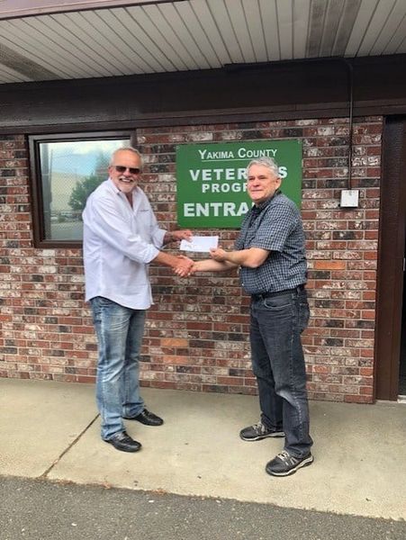YAKIMA REALTORDAY3 two men clasping hands in front of a building